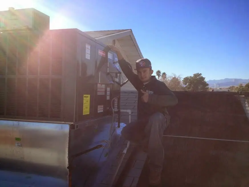 HVAC technician performing Air Duct Repair on a rooftop unit in Graham